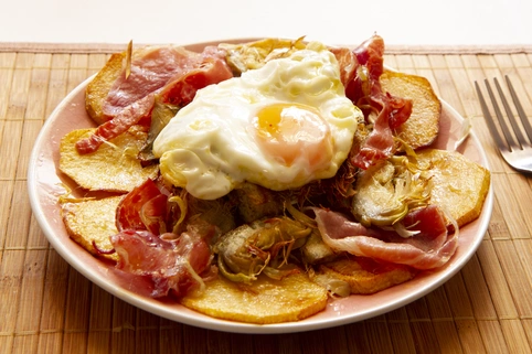 Patatas fritas con huevo roto por encima