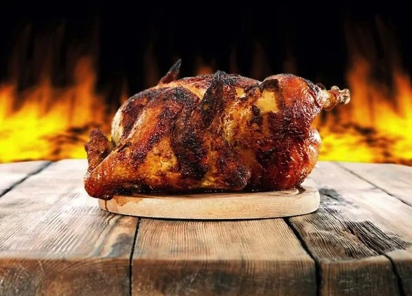 Pollo asado al carbón entero con patatas en Tizones