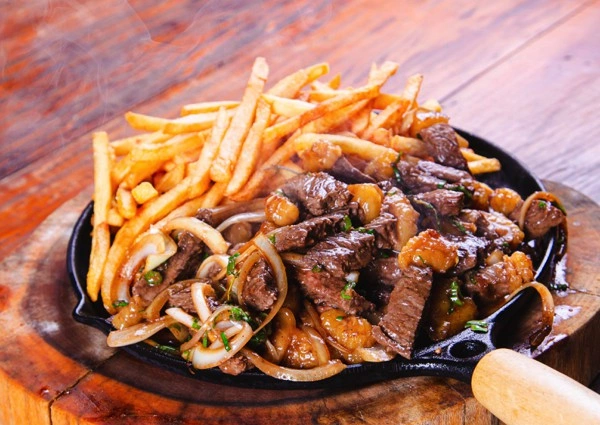 Salchipapa paisa: Patatas, salchicha, chorizo, chicharrón, maduritos, queso mozzarella y salsas